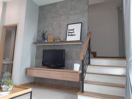 Modern living area with TV and staircase