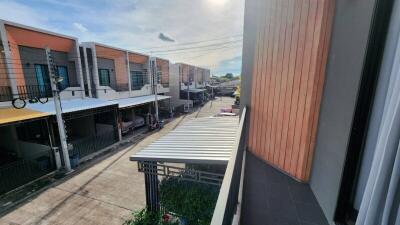 View from balcony overlooking street with modern townhouses