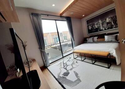 Modern bedroom with a large bed, wall art, and balcony access