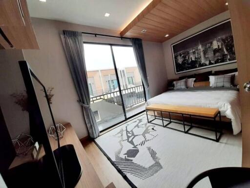 Modern bedroom with a large bed, wall art, and balcony access