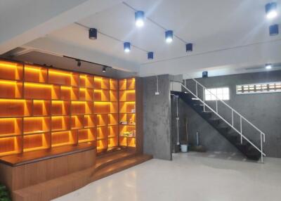 Modern living area with wooden shelves and staircase