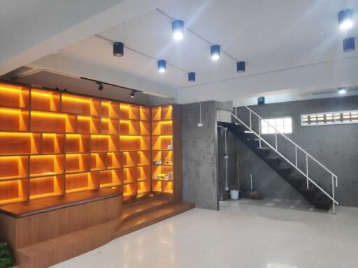 Modern living area with wooden shelves and staircase