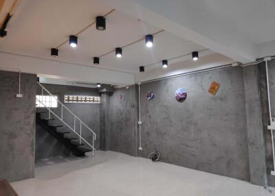 Finished basement with modern lighting and exposed concrete walls