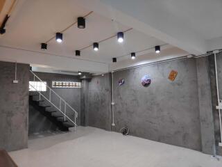 Finished basement with modern lighting and exposed concrete walls