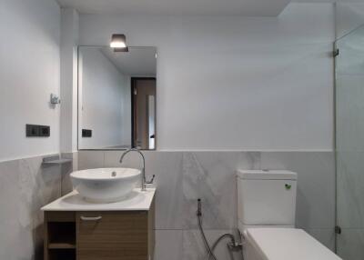 Modern bathroom with vanity, toilet, and shower area