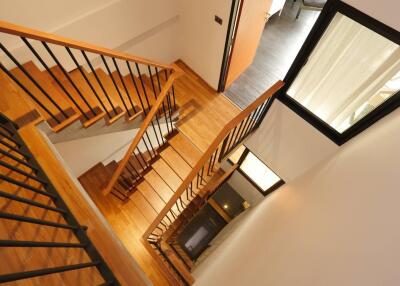 Modern staircase with wooden steps and black railings