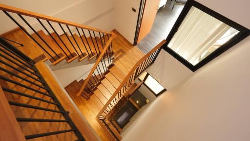 Modern staircase with wooden steps and black railings