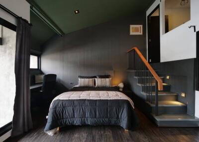 Modern bedroom with dark decor and loft area