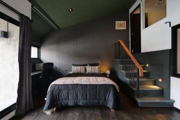 Modern bedroom with dark decor and loft area