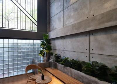 Modern indoor sitting area with wooden flooring and large windows