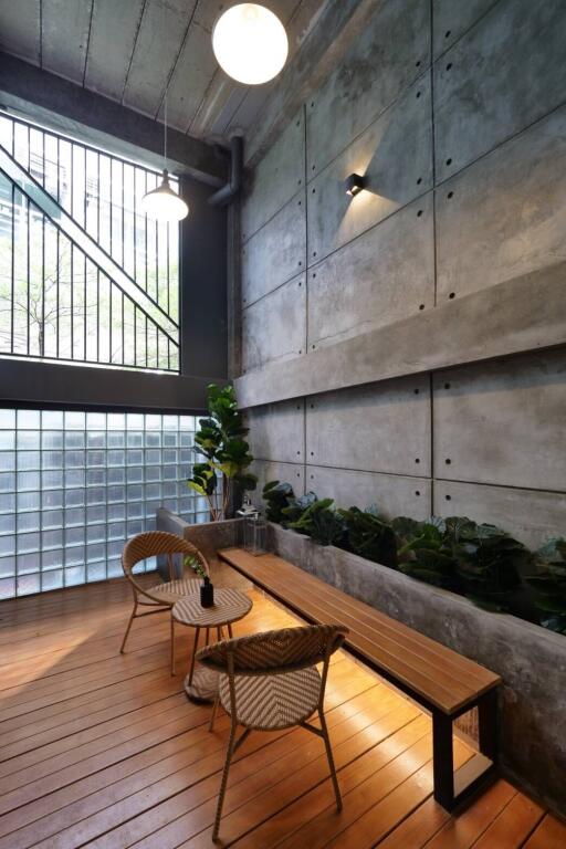 Modern indoor sitting area with wooden flooring and large windows