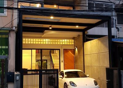 Three-story building with a garage and a white car parked in front