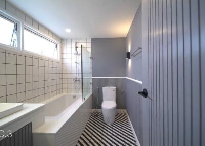 Modern bathroom with bathtub, shower, and geometric floor tiles