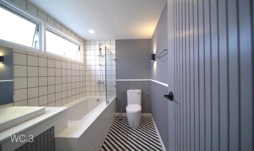 Modern bathroom with bathtub, shower, and geometric floor tiles