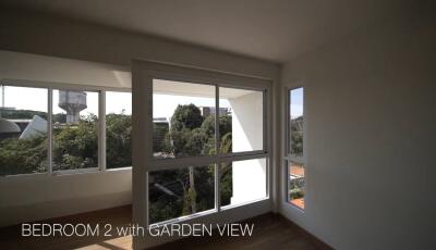 Bedroom with large windows and garden view