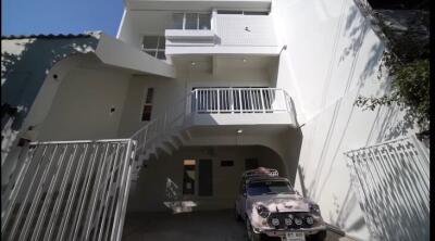 Three-story building exterior with car parked in driveway