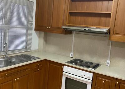 A kitchen with wooden cabinets and white appliances