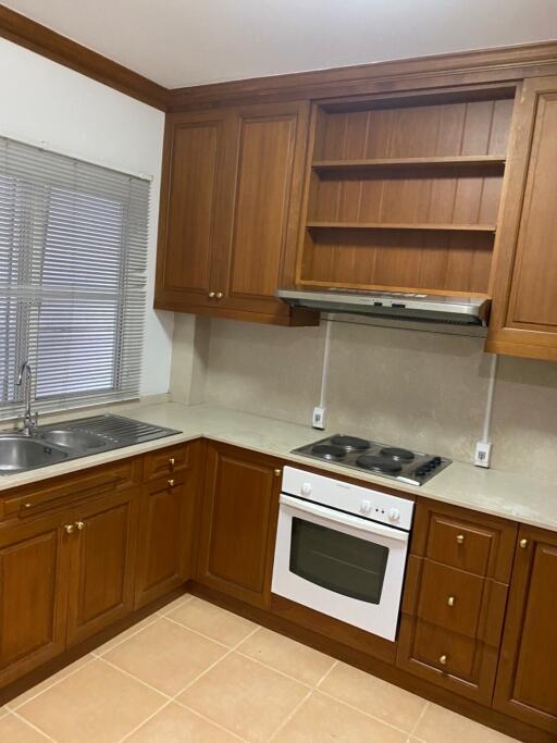 A kitchen with wooden cabinets and white appliances