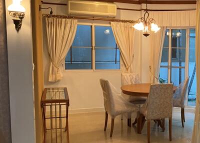 Dining area with round table and chairs next to a window