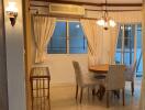 Dining area with round table and chairs next to a window