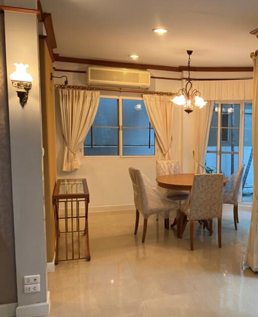 Dining area with round table and chairs next to a window