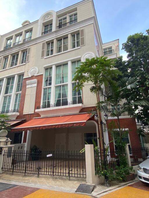 Four-story residential building with gated entrance and front garden