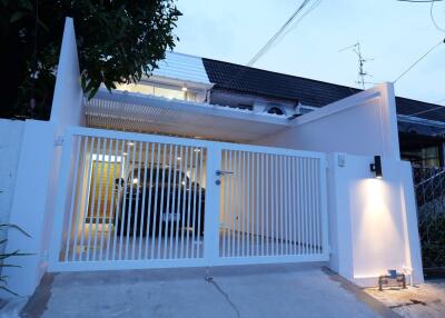 Front view of a modern house with a gated driveway