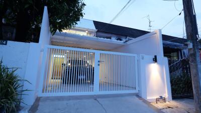 Front view of a modern house with a gated driveway