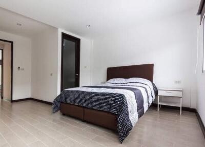 Modern bedroom with double bed, bedside table, and large window