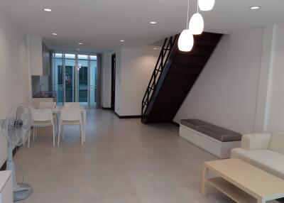 Modern living room with staircase and dining area