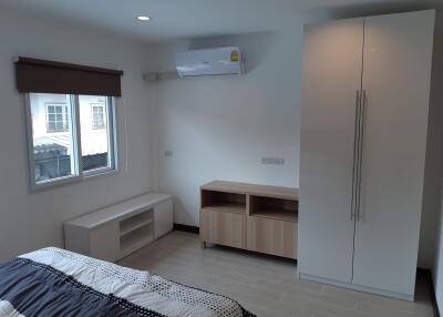 Bedroom with a bed, air conditioner, wardrobe, and a window