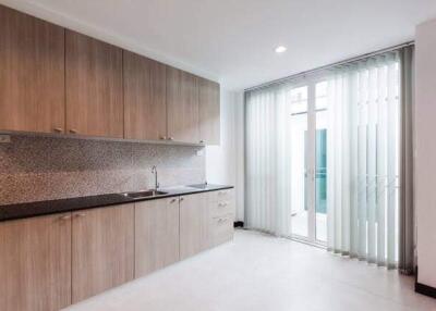 Modern kitchen with light wood cabinets and sliding glass door