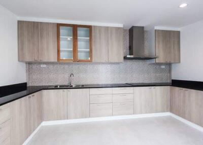 Modern kitchen with wood cabinets and black countertops