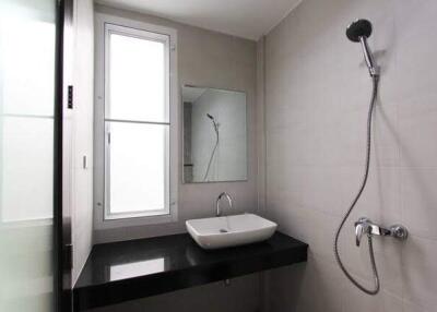 Modern bathroom with wall-mounted shower and sink area