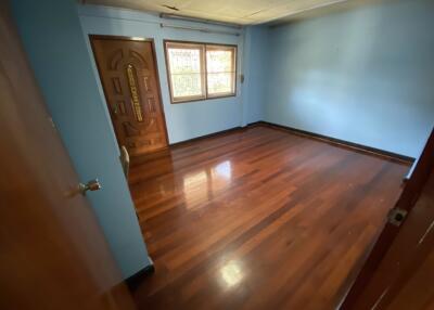 Empty bedroom with hardwood floor and window