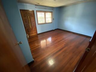 Empty bedroom with hardwood floor and window