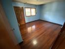 Empty bedroom with hardwood floor and window