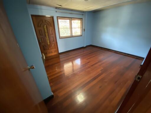 Empty bedroom with hardwood floor and window