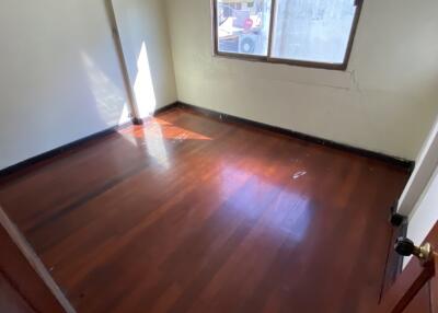 Empty bedroom with window and wooden floors