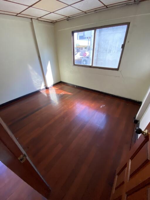 Empty bedroom with window and wooden floors