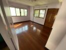 Empty room with hardwood floors and natural light