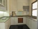 Modern kitchen with granite countertops and white cabinets.