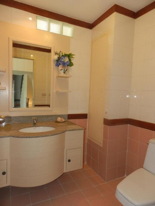 Modern bathroom with sink, mirror, shelves, and toilet