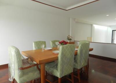 Elegant dining room with a wooden table and green cushioned chairs