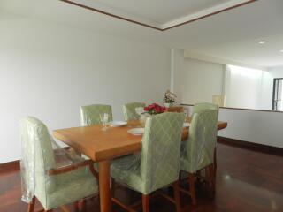 Elegant dining room with a wooden table and green cushioned chairs