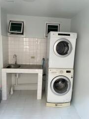 Laundry room with stacked washer and dryer