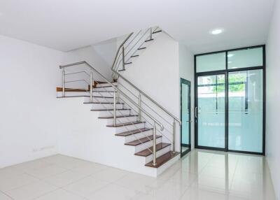 Staircase area with glass door and metal handrails