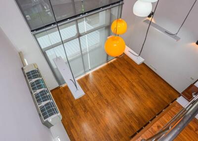 Modern living area with large windows and wooden flooring, view from above