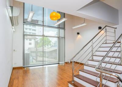 Spacious living area with large windows and stairs