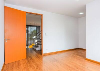 Modern empty bedroom with open door and wooden floor